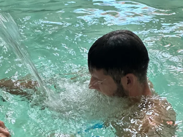 Un usuari sota el raig d'aigua termal de la piscina