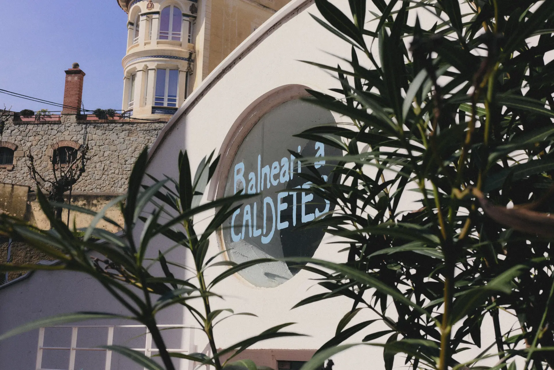 La façana del Balneari de Caldetes amb el logotip pintat a la finestra rodona